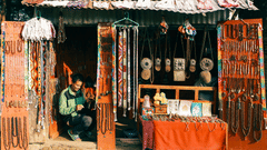 A person sitting inside a store selling local handicrafts on a sunny day