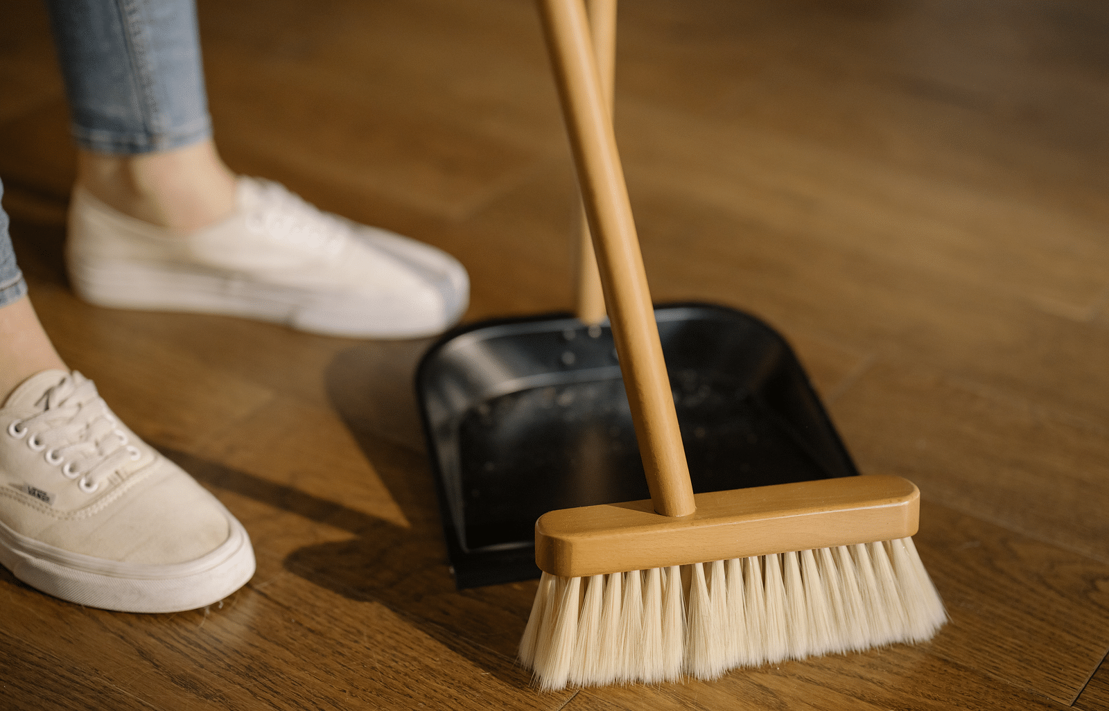 A person sweeping a wooden floor