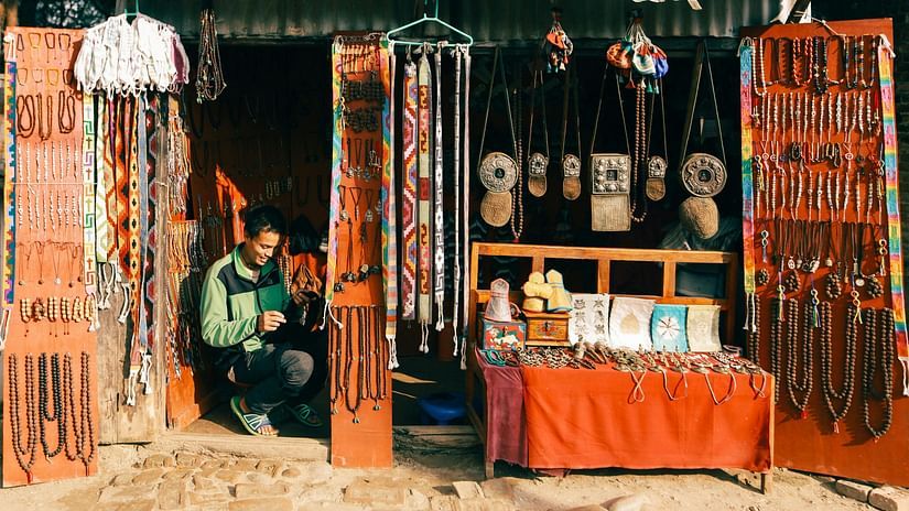 A person sitting inside a store selling local handicrafts on a sunny day