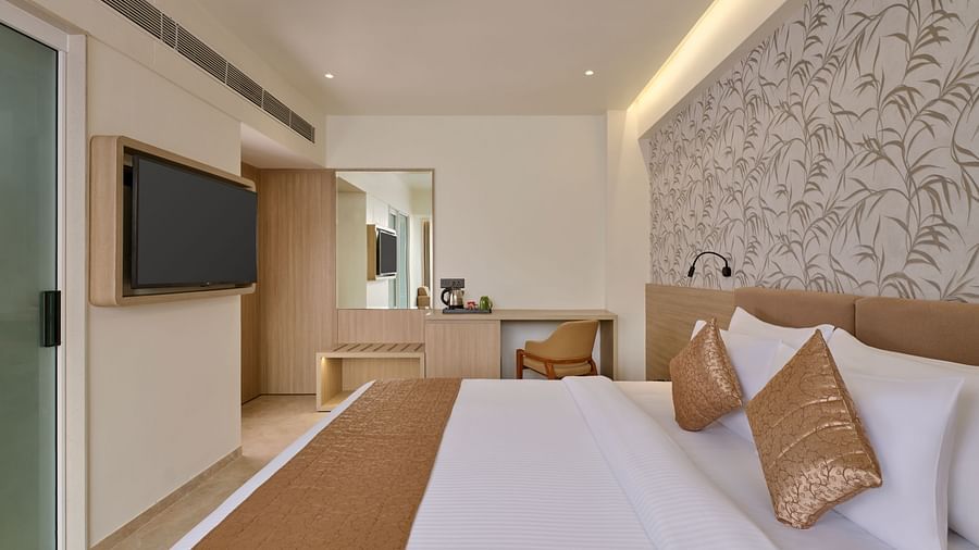 Comfortable hotel room with a cozy bed, a TV for entertainment, and a simple design - Biznotel by Pride Motera, Ahmedabad