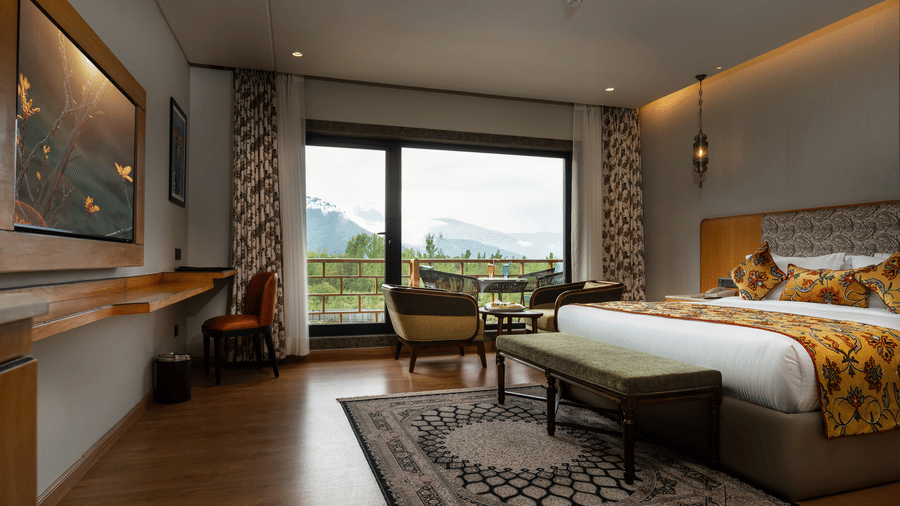 Spacious luxury suite at Mountnoor Sarovar Premiere, Pahalgam featuring modern décor and scenic balcony views.