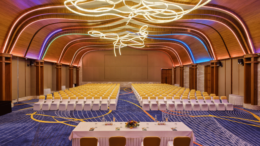 The illuminous Boito Voyage at Swosti Premium Beach Resorts, Puri, with chairs, and tables  under a unique decoration.