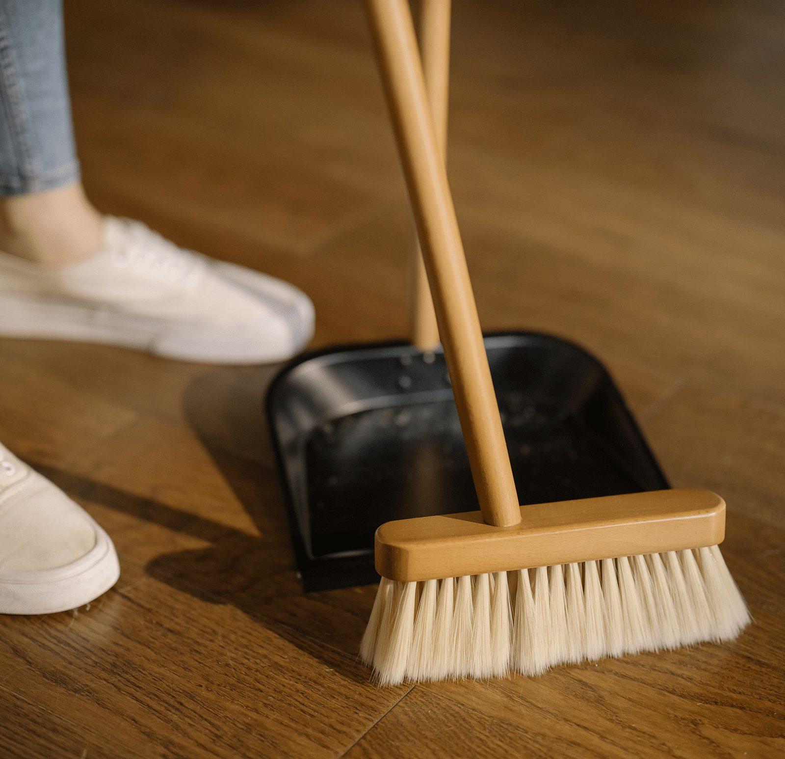 A person sweeping a wooden floor