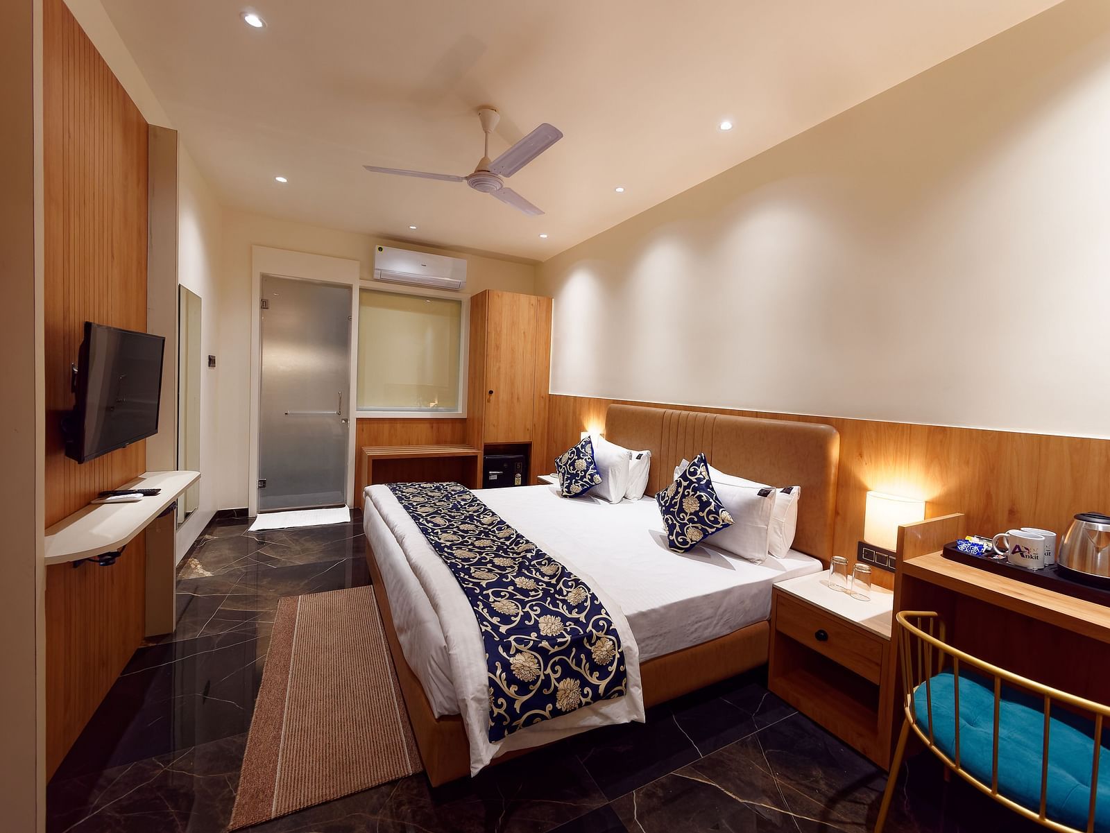 A double bed and a television in a room at M Square Hotels & Resorts