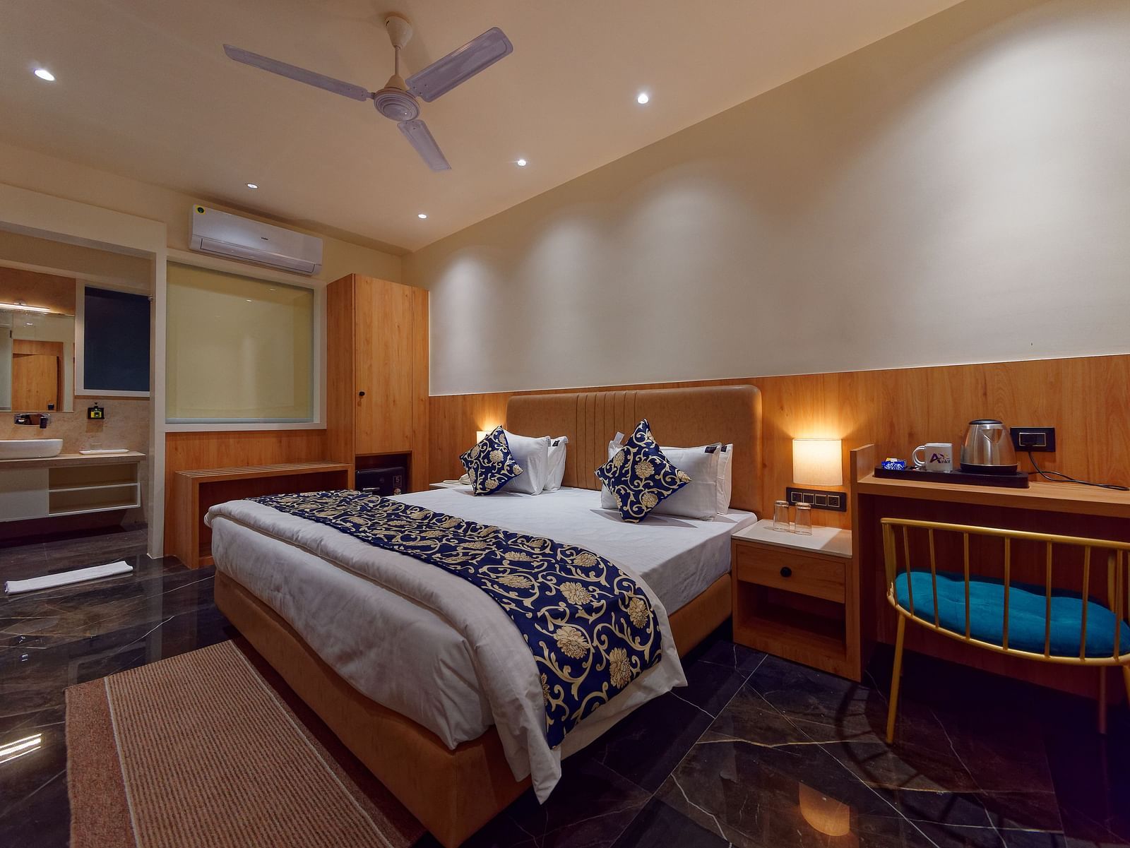 A double bed and a work desk and chair in a room at M Square Hotels & Resorts