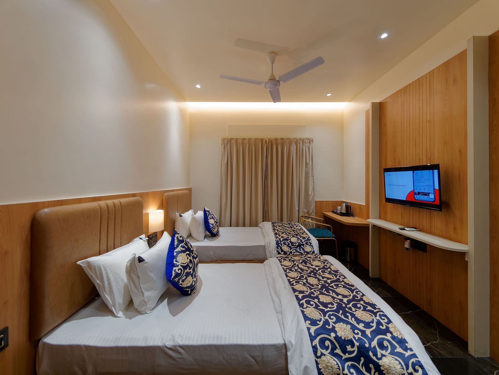Twin beds and a television in a room at M Square Hotels & Resorts
