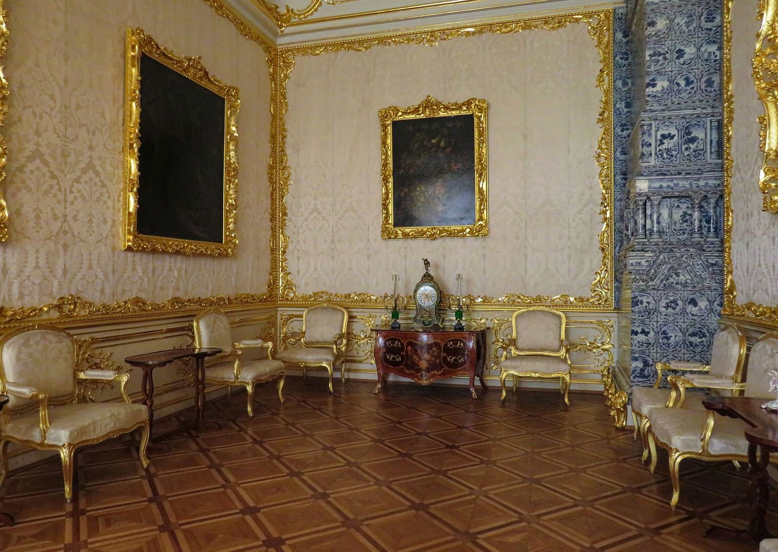 An overview of the interiors of a palace with gold detailing and brown flooring.