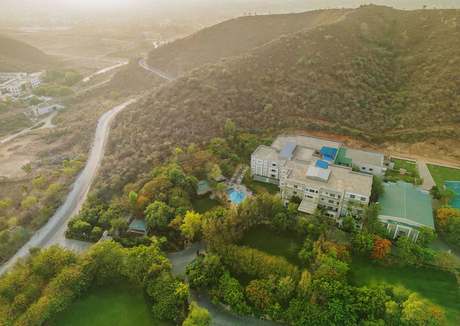 An aerial view of Essentia Luxury Resort & Spa, Udaipur with a road next to it
