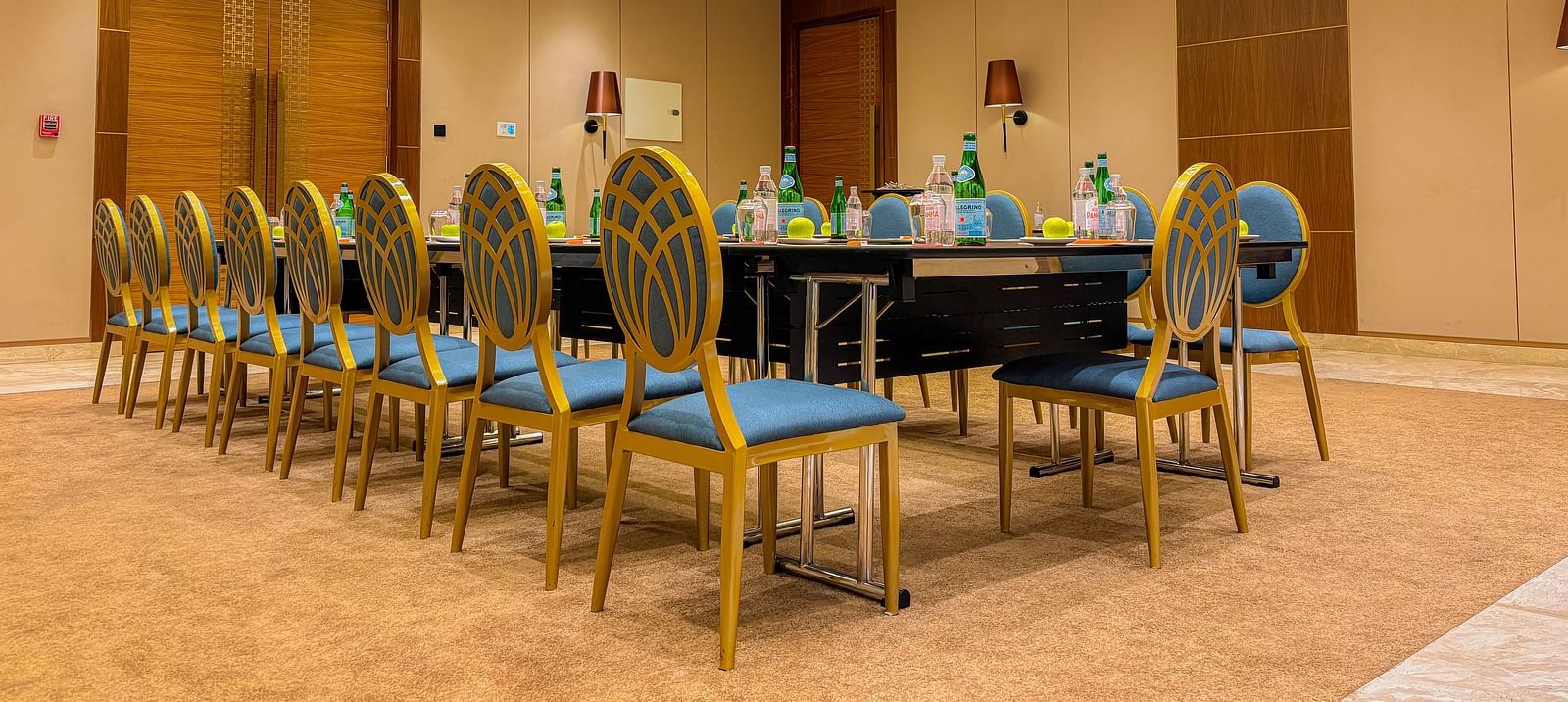 Banquet Hall at KertelSuites, featuring a long table with elegant chairs, complemented by a stylish ceiling and ambient lighting