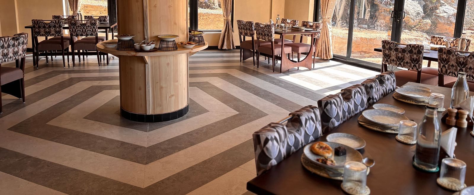 A dining area at The Chamomile Estate with tables and chairs set atop a patterned floor.