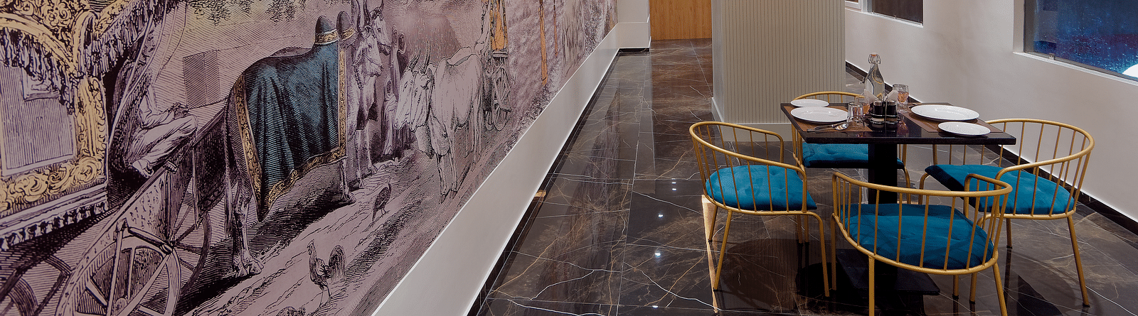 Image of seating area with chairs and tables and mural on the wall at Ankit Hotel, Jabalpur
