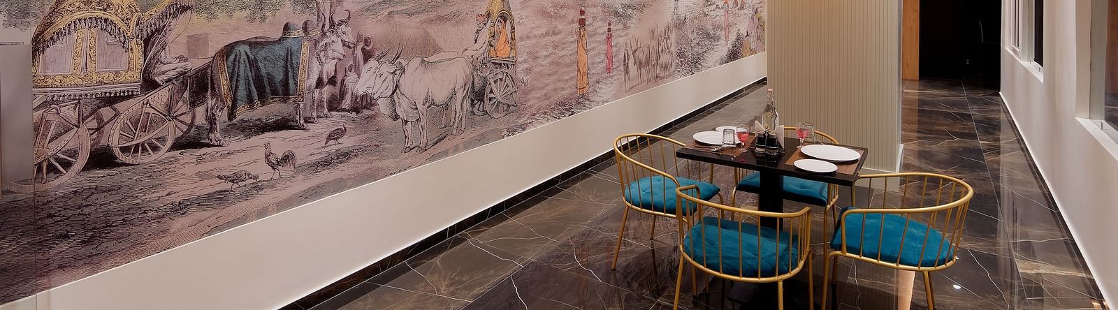 Image of seating area with chairs and tables and mural on the wall at Ankit Hotel, Jabalpur