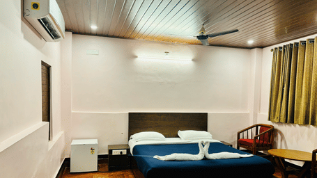 Standard room at Paradise Lagoon Resort, Udupi, featuring a double bed and a mini-refrigerator.