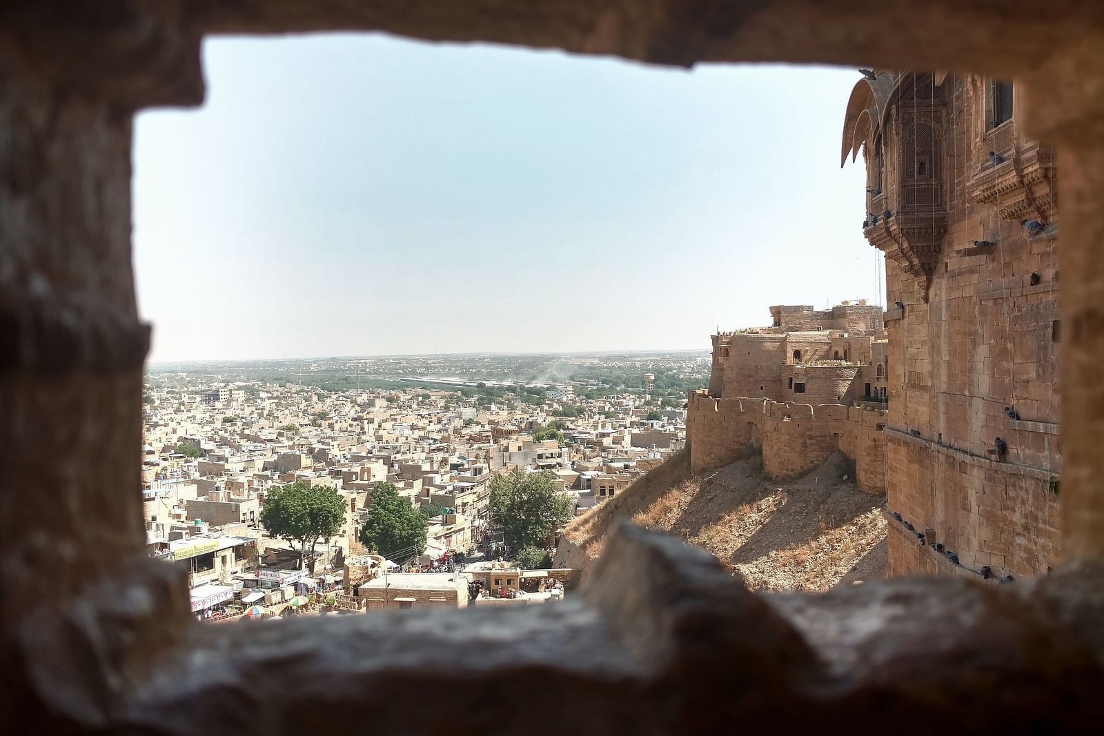 a shot of the city during the daytime taken from inside an opening of a fort