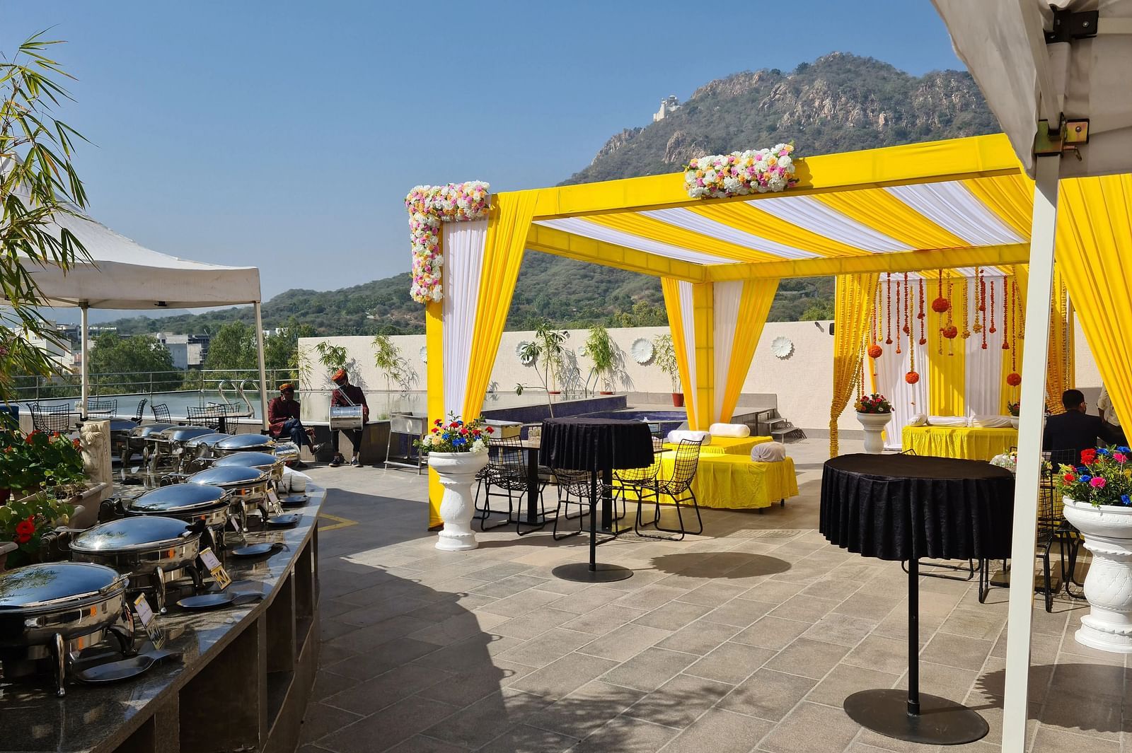 Outdoor tent with tables, mountain view.
