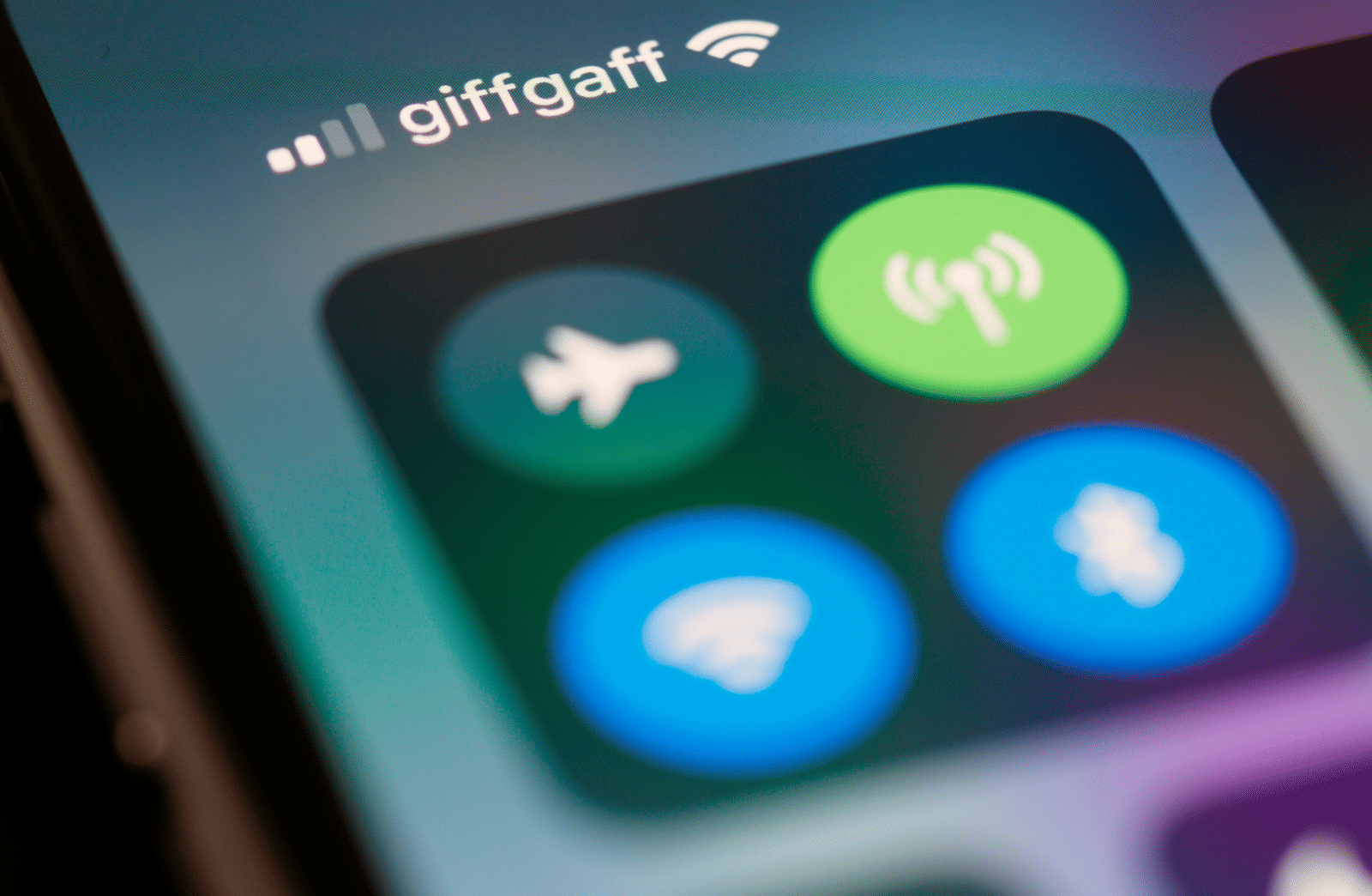 A close-up shot of a smartphone screen showing the control centre with Wi-Fi and Bluetooth icons lit up.