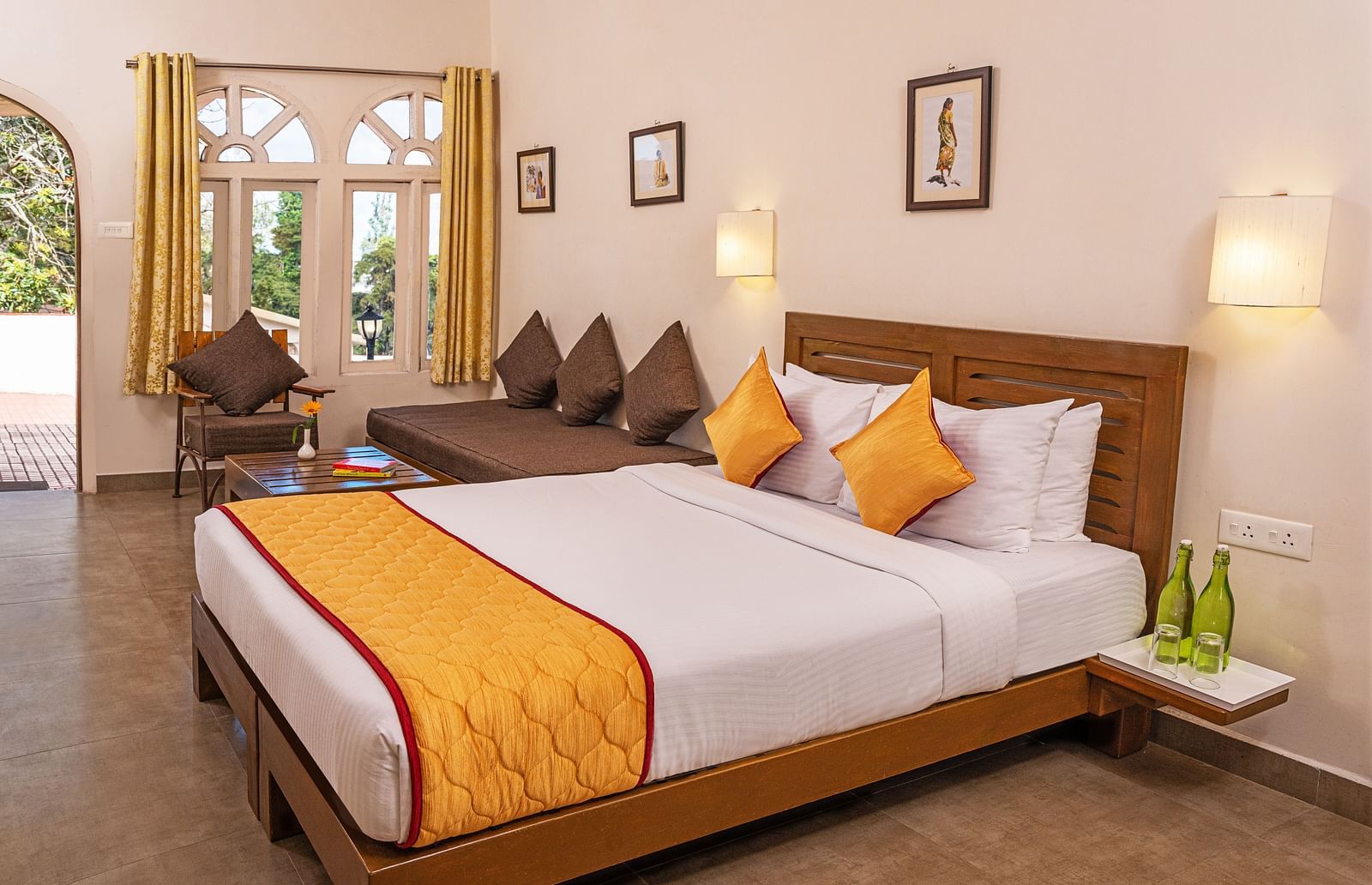A large bedroom with double-size bed an a small sitting area beside it | Mango Hill, Kodaikanal