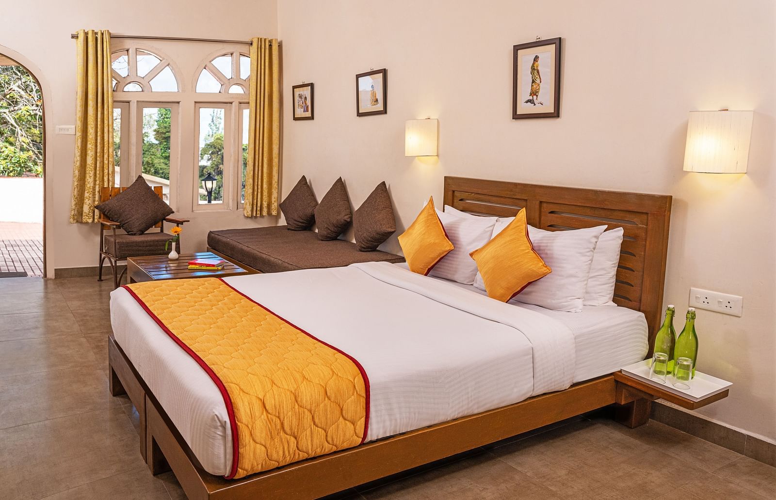 A large bedroom with double-size bed an a small sitting area beside it | Mango Hill, Kodaikanal