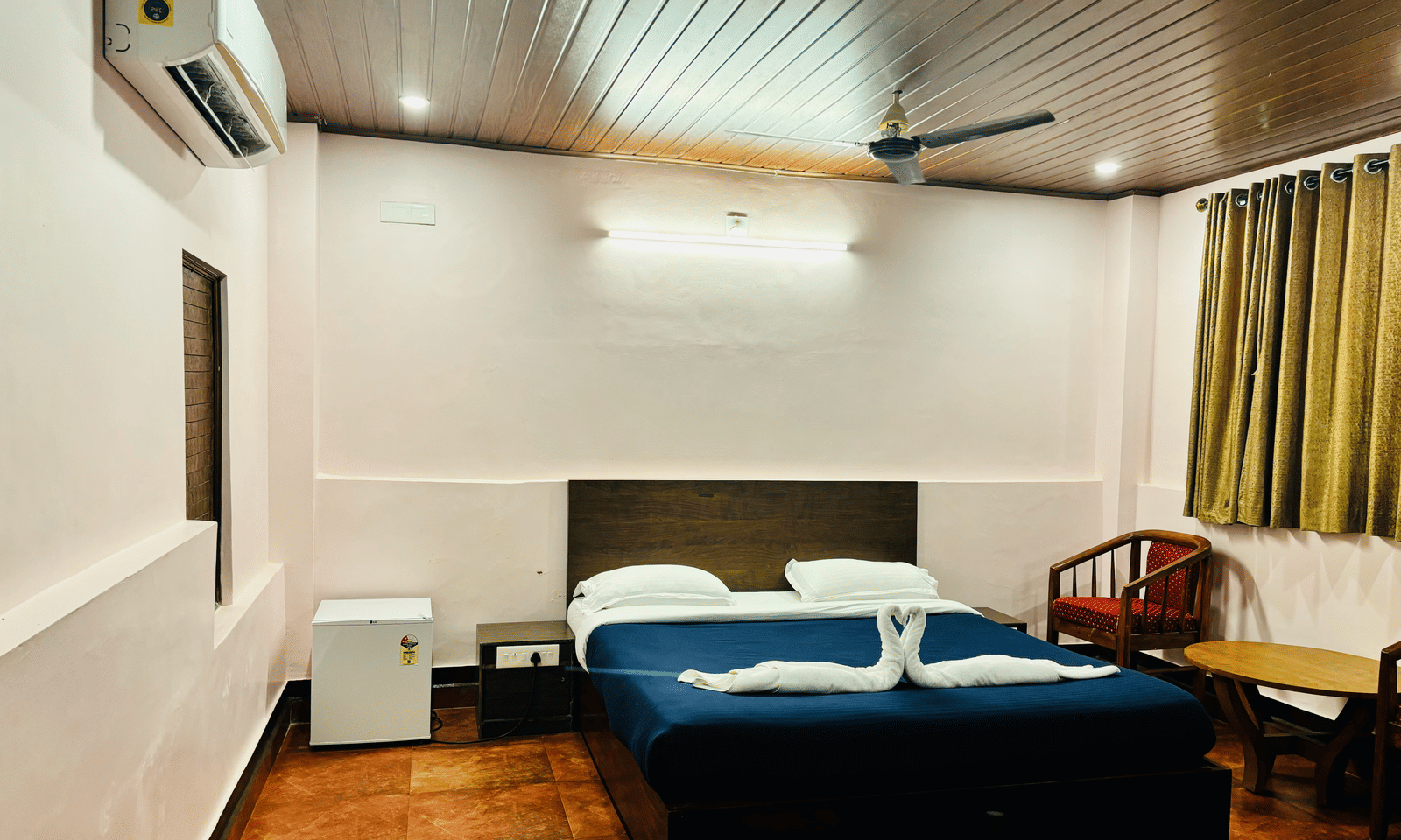 Standard room at Paradise Lagoon Resort, Udupi, featuring a double bed and a mini-refrigerator.