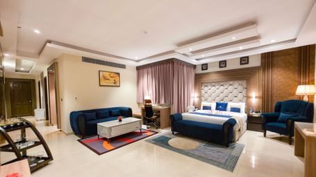 Full view of the Presidential Suite featuring the master bedroom along with a separate seating area in the corner at The Meriton.
