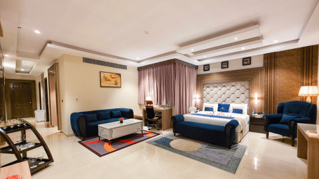 Full view of the Presidential Suite featuring the master bedroom along with a separate seating area in the corner at The Meriton | Stay in New Delhi