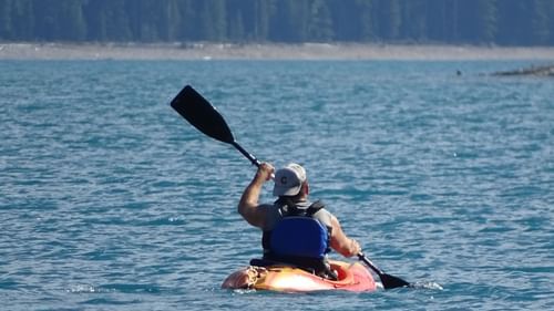 A man kayaking in a water body during the day.