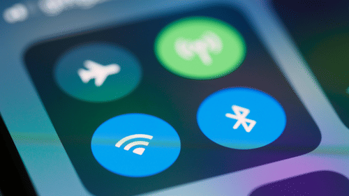 Close-up of smartphone screen showing WiFi, Bluetooth, airplane mode, and hotspot icons in control center.