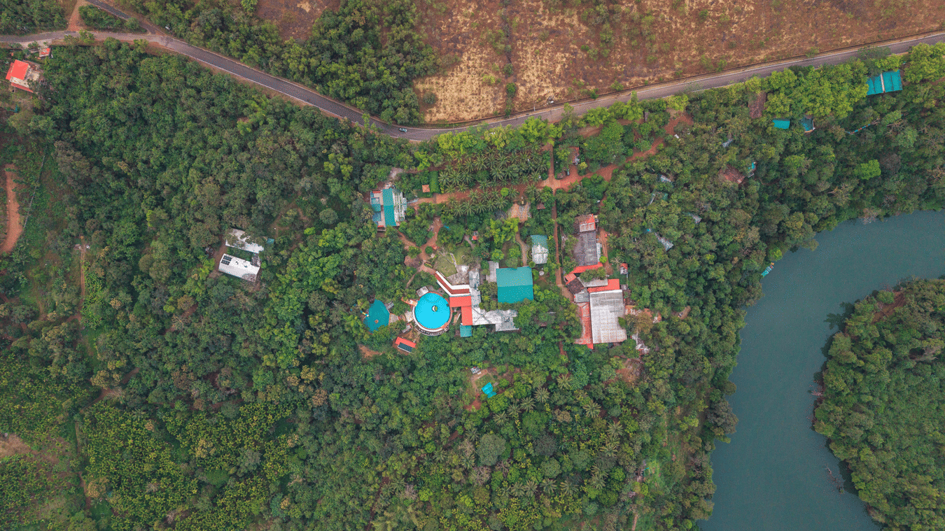 A bird's-eye view of a river curving through a thick green forest.