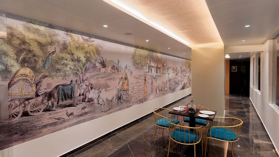 Image of seating area with chairs and tables and mural on the wall at Ankit Hotel, Jabalpur