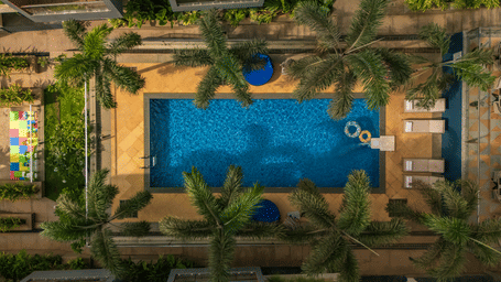 Top-down view of a pool with a blue logo design on the surrounding deck at Perfectstayz Premium Carnival Suites, Marra, Goa.