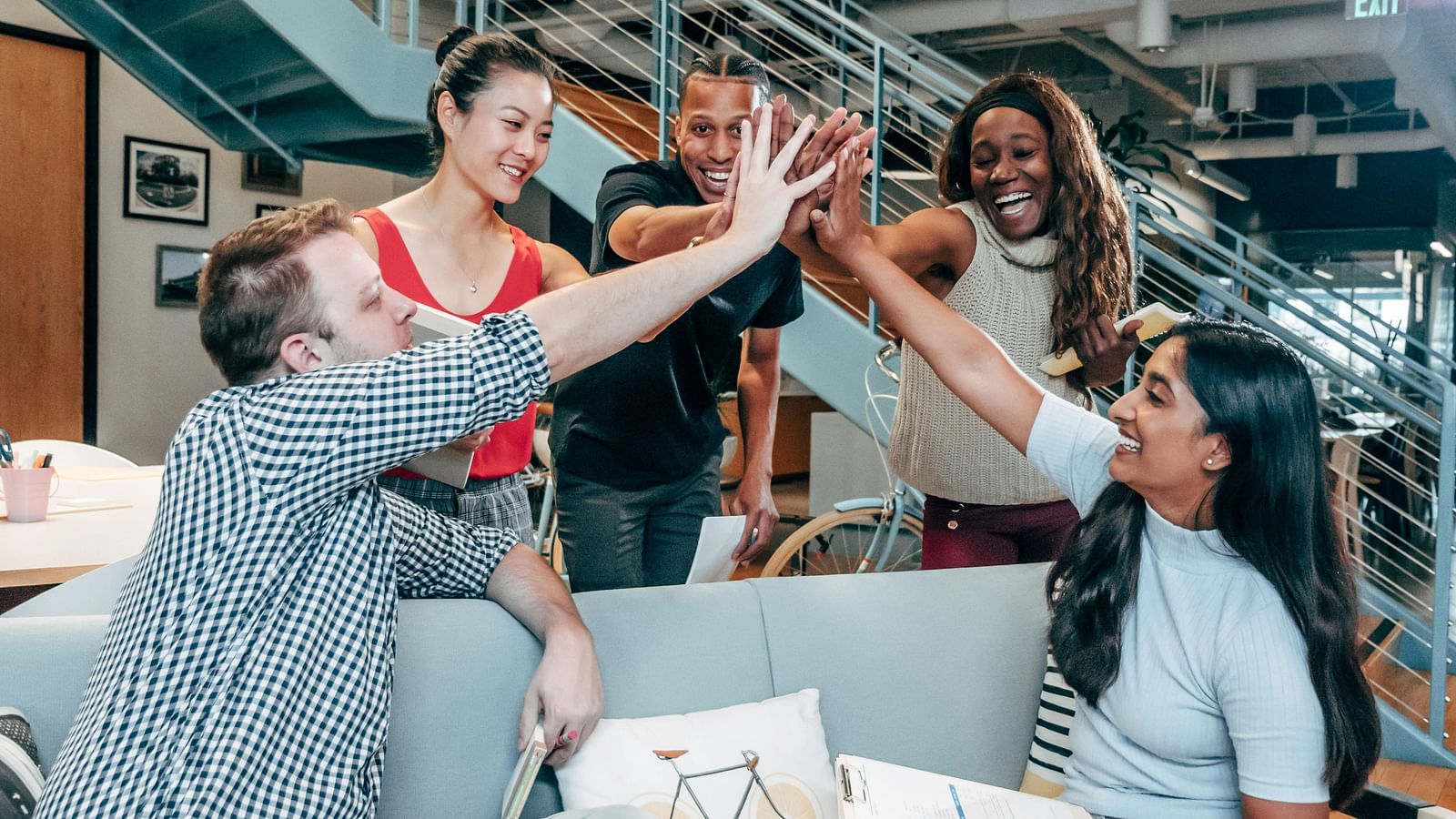Group of colleagues giving a high-five in a modern office setting