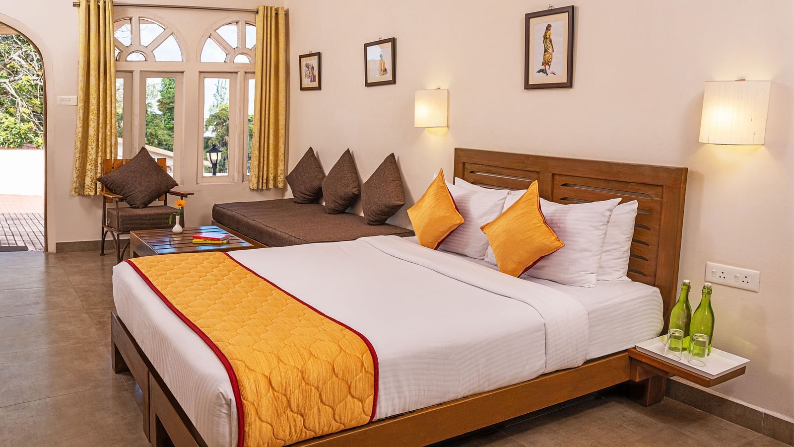 Premium room with a queen-size bed, orange bedding, and a sitting area by the window.