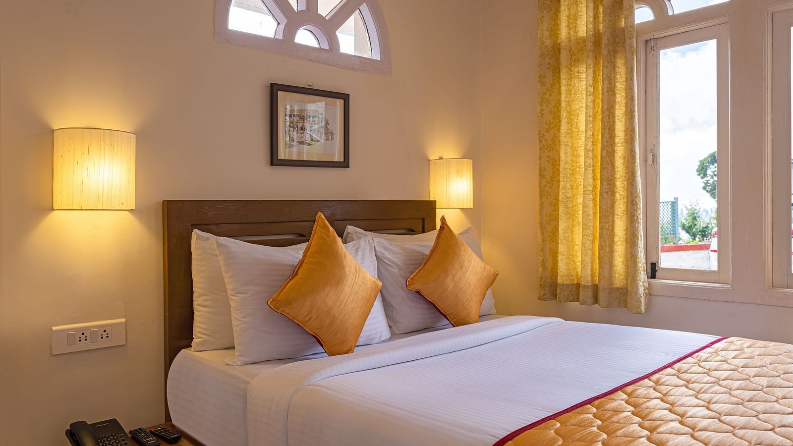 Superior room with a cozy queen-size bed, orange bedding, and large windows.