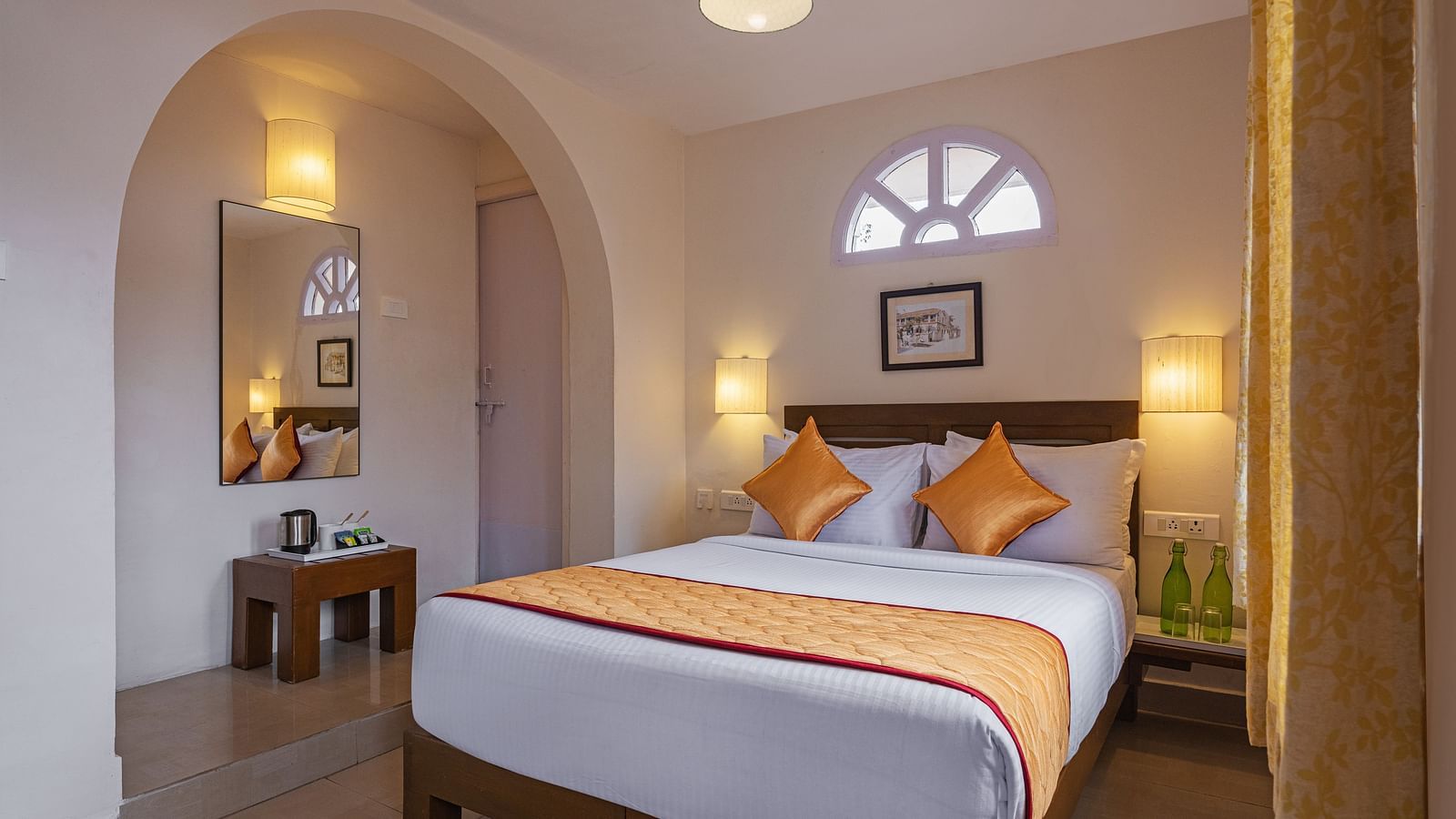 Superior room with a queen-size bed, orange bedding, and natural light from arched windows.