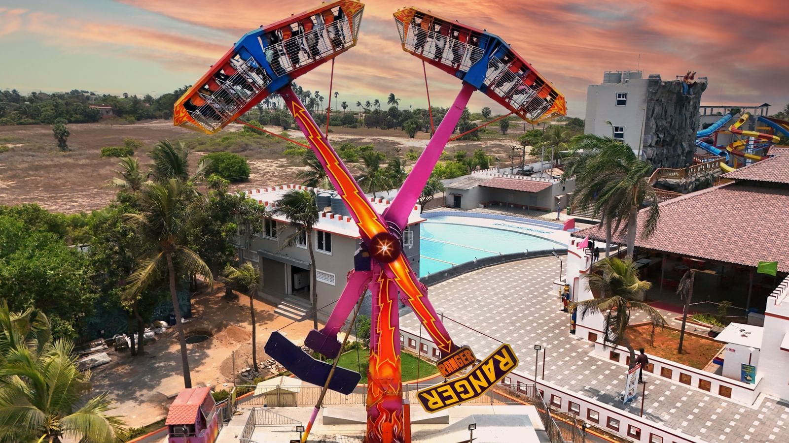 Kamikaze Ranger in action with people in it at MGM Dizzee World in Chennai under a vibrant sky
