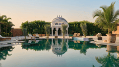 Elegant domed pavilion reflected in a calm infinity pool with palm trees in the background at Mukundra Sarovar Premiere, Kota.
