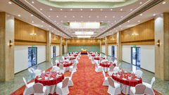 Image of a banquet hall in Bhopal with round tables and chairs arranged around it at Tulip Inn, Bhopal.