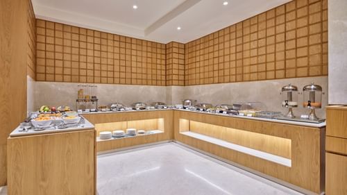 Hotel buffet area with a variety of food choices, ready for guests to serve themselves - Biznotel by Pride Motera, Ahmedabad