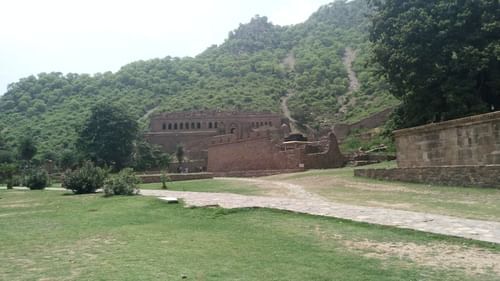 an overview of the road leading to the bhangarh fort with a hill in the background