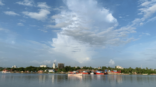 A view from the ocean of the Mangalore coastline with a boat in the picture