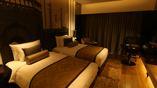 Superior Twin Room at Pride Plaza Hotel, New Delhi featuring a sofa chair, a working chair, and a centre table.