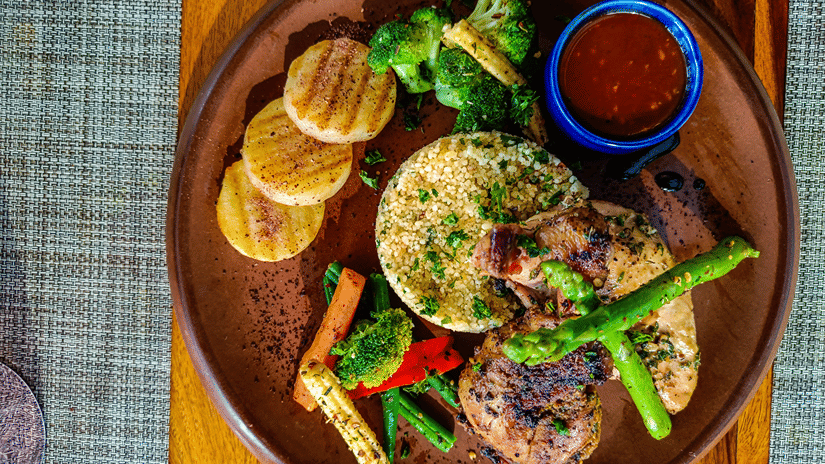 Quinoa, sauce, grilled vegetables, and chicken as seen from above - Karma Lakelands.