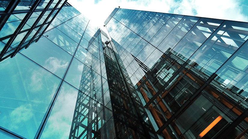 A view of office buildings from below of the glass enclosure