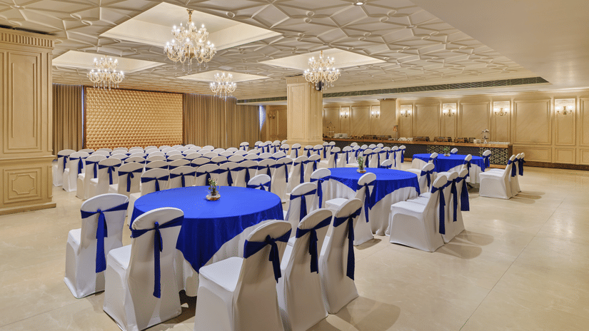 Large event hall featuring ornate ceilings and blue-themed seating - Pride Elite Gandhinagar
