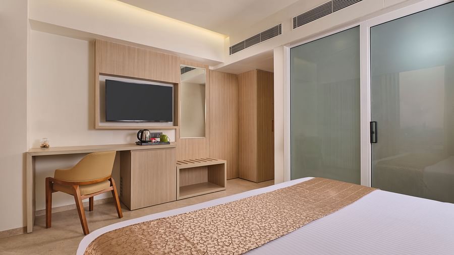 Hotel room with workspace, TV, and comfortable bed for a relaxing stay - Biznotel by Pride Motera, Ahmedabad