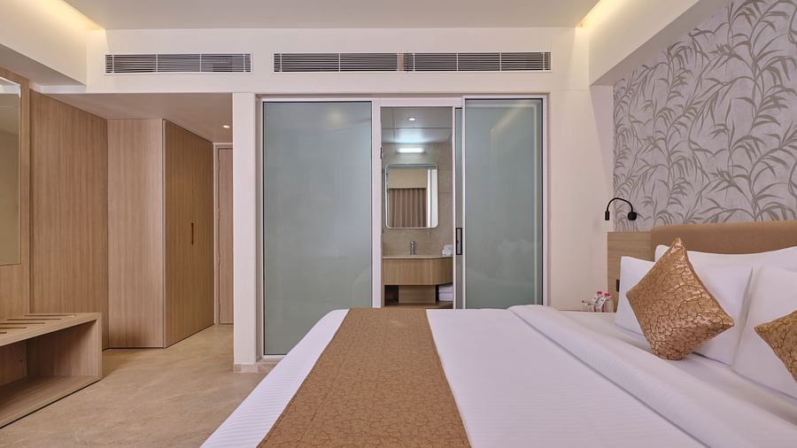 Modern hotel room with king bed, sleek design, and warm lighting - Biznotel by Pride Motera, Ahmedabad