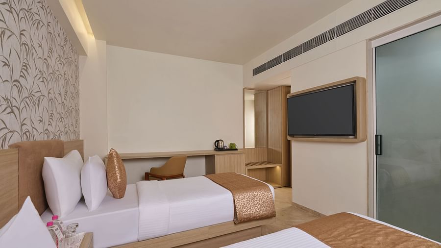 Modern hotel room with king bed, neutral tones, and a scenic view - Biznotel by Pride Motera, Ahmedabad