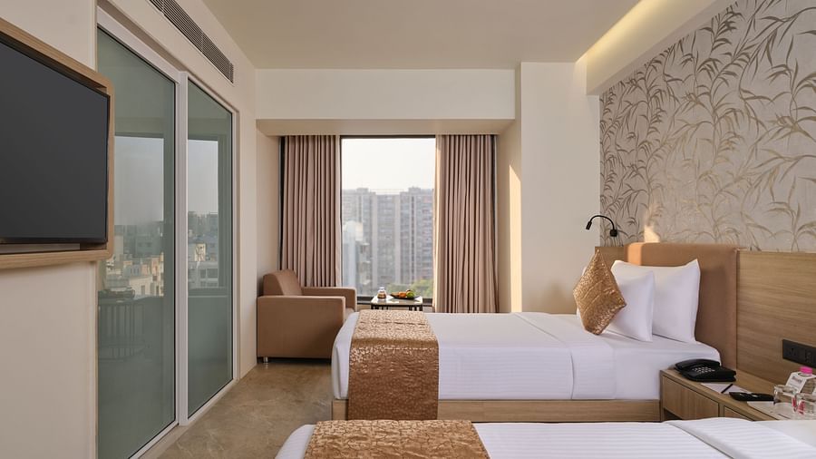Spacious hotel room with two beds, city view, and modern amenities - Biznotel by Pride Motera, Ahmedabad