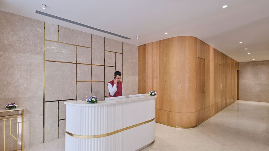 Stylish hotel reception with curved desk, concierge, and contemporary design - Biznotel by Pride Motera, Ahmedabad
