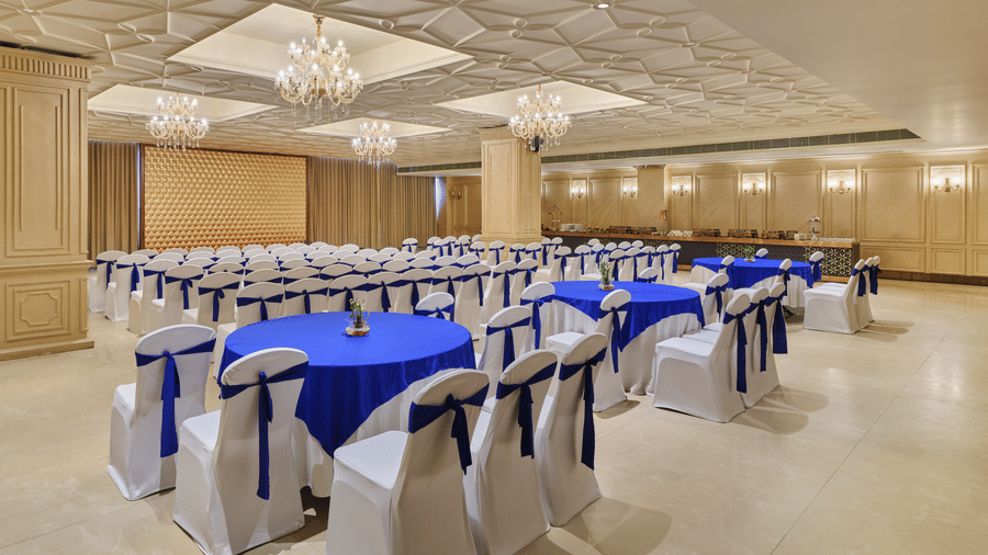 Large event hall featuring ornate ceilings and blue-themed seating - Pride Elite Gandhinagar